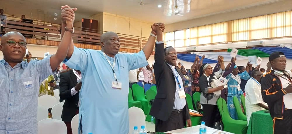 CCSL members and Rev. Fidon Mwombeki holding hands during the celebrations 